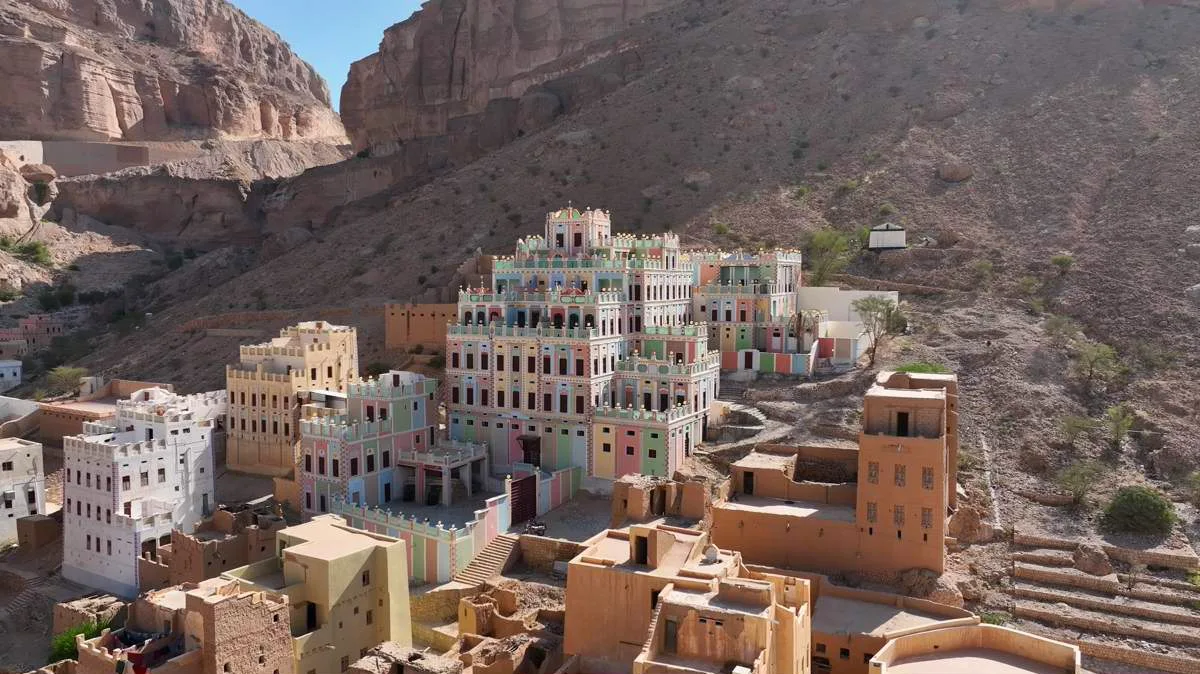 Colorful Buqshan Palace surrounded by traditional mudbrick buildings in Wadi Doan, Yemen